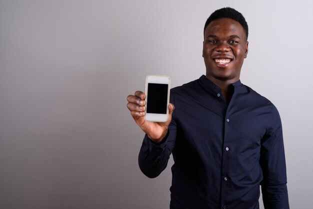 Photo de Studio de jeune homme d'affaires africain avec téléphone mobile sur fond blanc