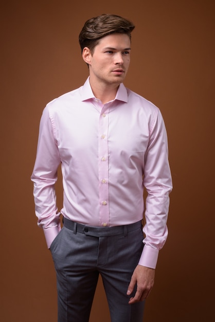 Photo photo de studio de jeune homme d'affaires beau avec chemise rose