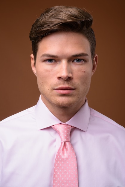 Photo de Studio de jeune homme d'affaires beau avec chemise rose