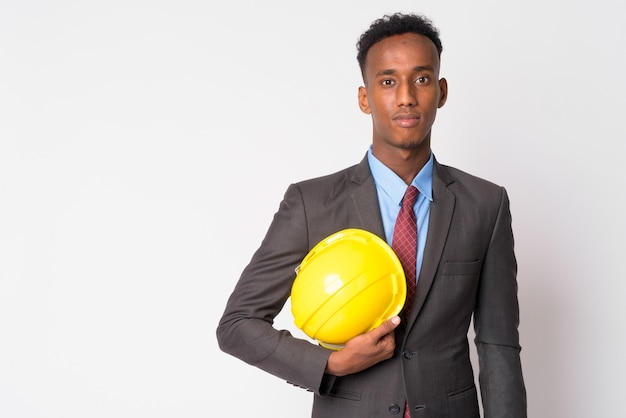 Photo de Studio de jeune homme d'affaires beau avec des cheveux afro portant costume contre blanc