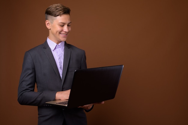 Photo de Studio de jeune homme d'affaires beau contre backgrou brun