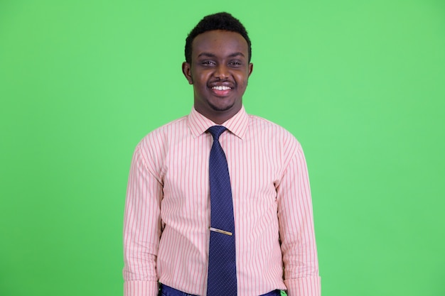 Photo de Studio de jeune homme africain aux cheveux afro sur fond vert