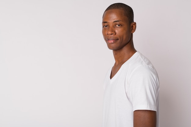 Photo de Studio de jeune homme africain chauve beau sur fond blanc