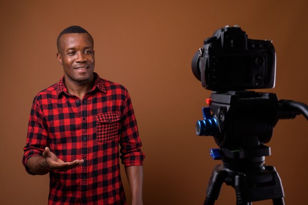 Photo de Studio de jeune homme africain sur fond marron