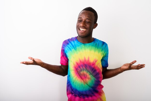 Photo de Studio de jeune homme africain noir heureux, haussant les épaules