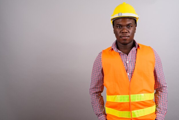 Photo de Studio de jeune homme africain travailleur de la construction sur fond blanc