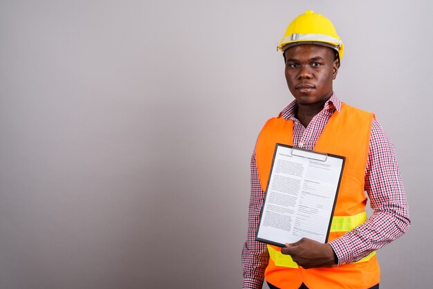 Photo de Studio de jeune homme africain travailleur de la construction sur fond blanc