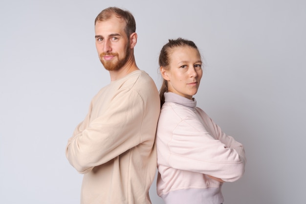 Photo de Studio de jeune homme barbu et belle jeune femme ensemble contre le blanc