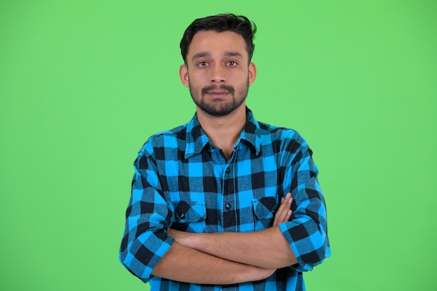 Photo de Studio de jeune homme hipster persan barbu beau contre clé chroma avec fond vert