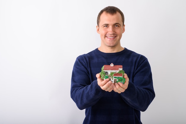 Photo de Studio de jeune homme musclé heureux souriant tout en maintenant ho