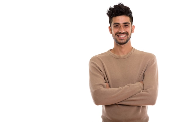 Photo de Studio de jeune homme persan heureux souriant avec les bras croisés