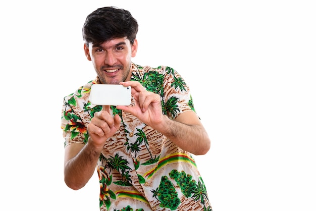 Photo de Studio de jeune homme persan heureux souriant tout en prenant pict