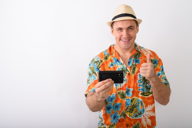 Photo de Studio de jeune homme touriste musclé heureux souriant tout en ta