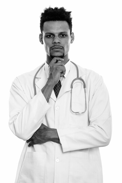 Photo de Studio de jeune médecin africain barbu beau isolé sur fond blanc en noir et blanc