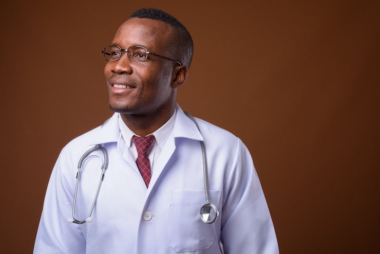 Photo photo de studio de jeune médecin homme africain sur fond marron