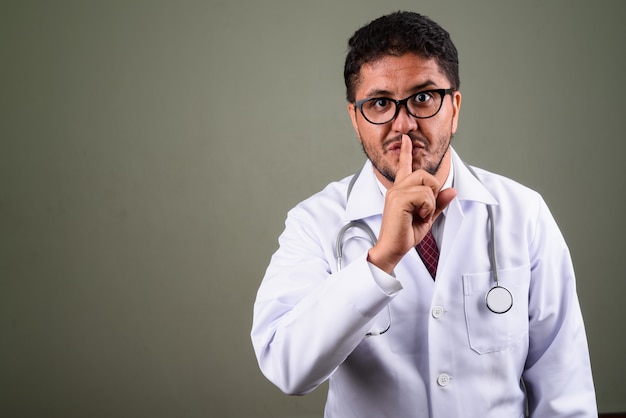 Photo de Studio de médecin homme barbu contre coloré