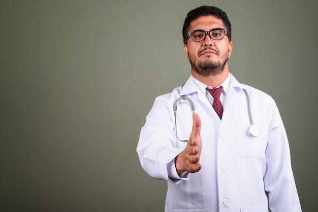 Photo de Studio de médecin homme barbu contre coloré