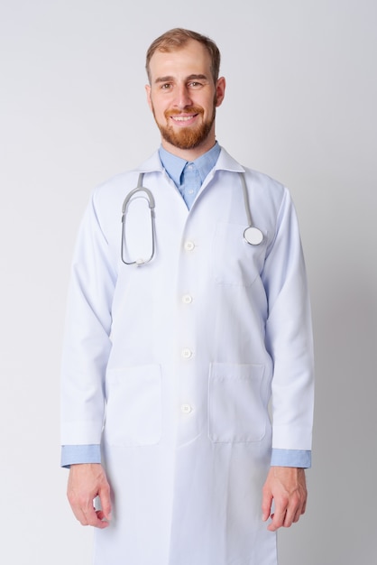 Photo de Studio de médecin jeune homme barbu contre blanc