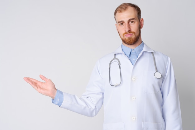 Photo de Studio de médecin jeune homme barbu contre blanc