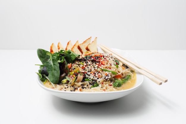 Photo de studio d'une soupe de nouilles ramen asiatiques au tofu fumé et aux épinards