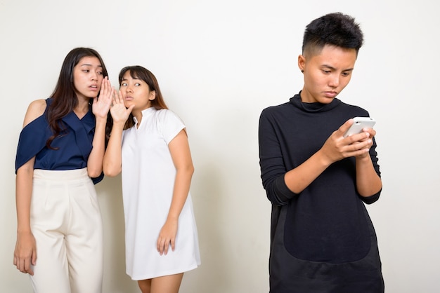 Photo de Studio de trois belles jeunes femmes asiatiques en tant qu'amis ensemble sur fond blanc