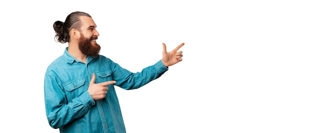 Photo de taille de bannière d'un homme barbu pointant de côté vers l'espace de copie blanche