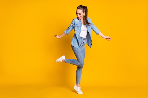 Photo en taille réelle d'une fille assez franche et satisfaite, profitez de la discothèque du week-end de danse et portez des chaussures de sport de bonne tenue isolées sur un fond de couleur vive