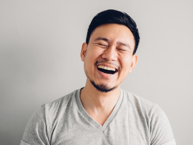 Photo de la tête d&#39;un homme asiatique avec le visage de rire. sur fond gris