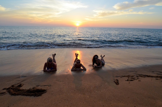 Photo de trois filles allongées sur la plage et se détendre