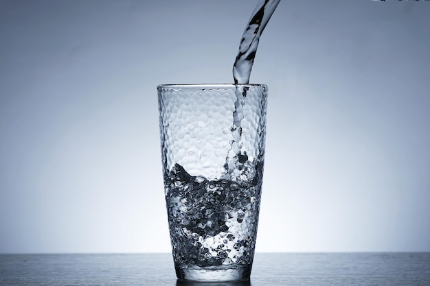 Photo de verser de l'eau dans un verre d'eau