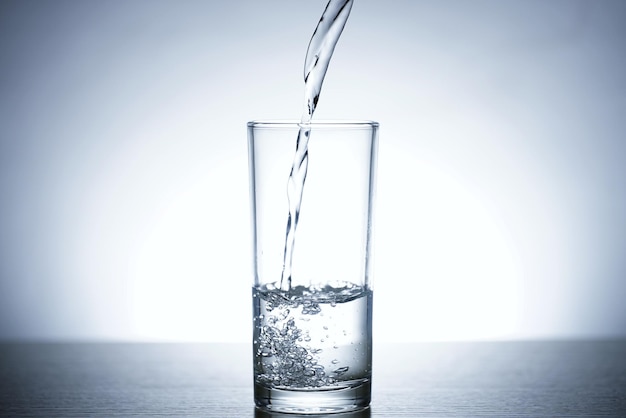 Photo de verser de l'eau dans un verre d'eau