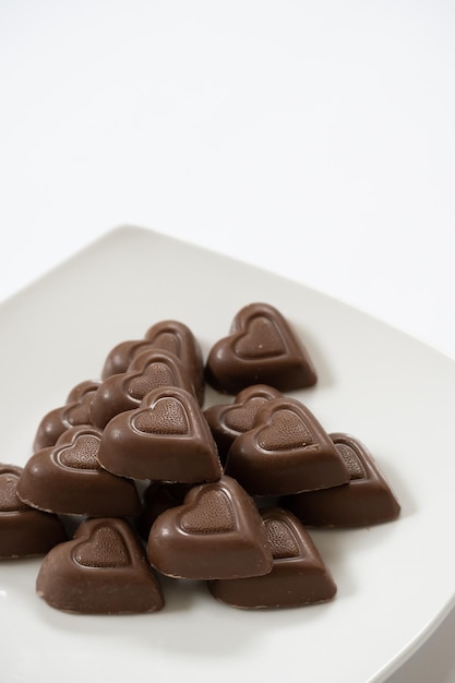 Photo verticale de chocolats coeur sur fond blanc avec copie espace