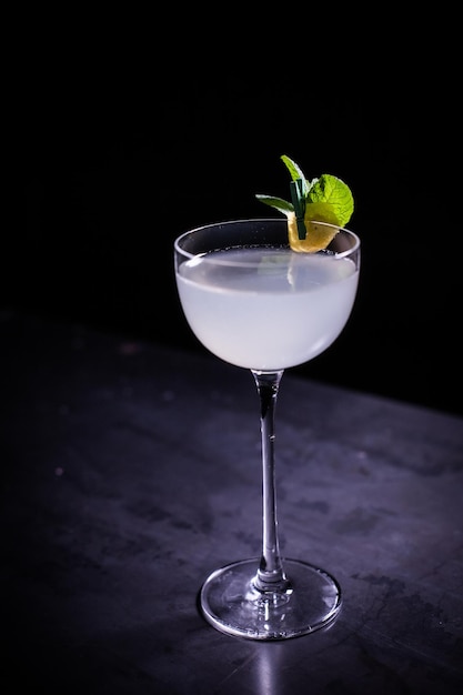 Photo une photo verticale d'un cocktail classique du côté sud avec du citron vert et de la menthe sur fond noir