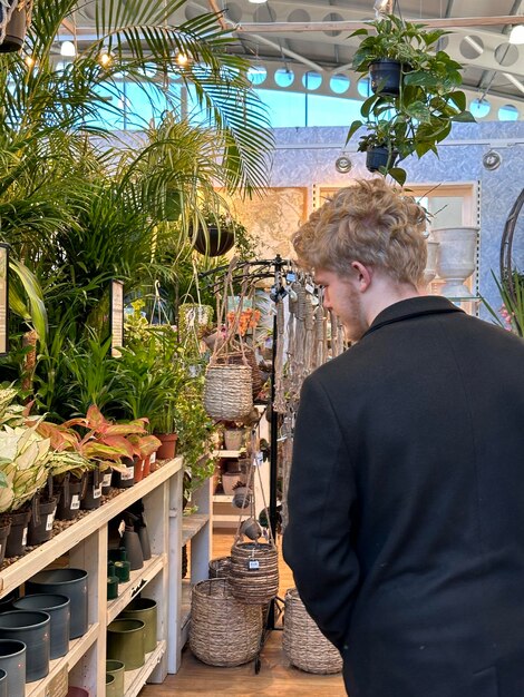 Photo une photo verticale coupée d'un client masculin achetant des plantes dans un magasin de jardinage