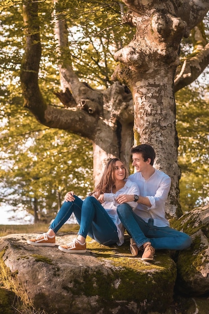 Photo verticale d'un couple assis ensemble dans un rocher dans un parc national