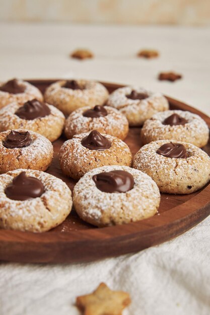 Une photo verticale de délicieux biscuits de Noël avec du chocolat sur une table blanche