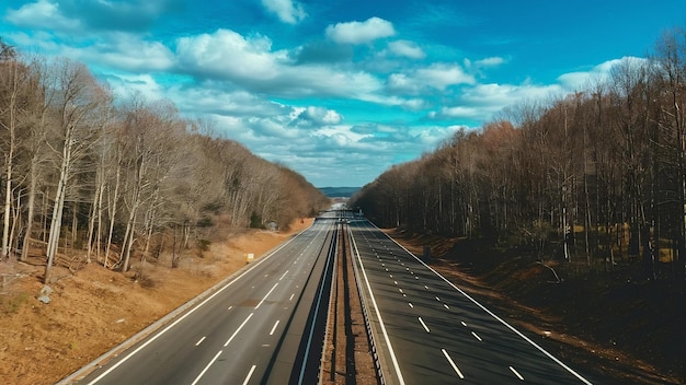 Une photo verticale en haut angle d'une autoroute entourée d'arbres sous le ciel bleu