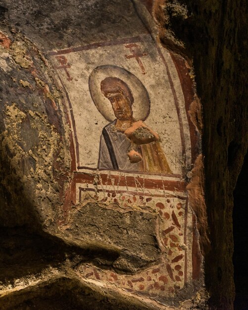 Photo une photo verticale d'une peinture religieuse dans les catacombes de san gennaro, rione sanita, naples, italie