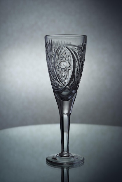 Une photo verticale d'un verre de champagne vide sur fond gris