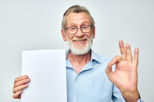 Photo d'un vieil homme à la retraite tenant une feuille de papier fond posant fond isolé