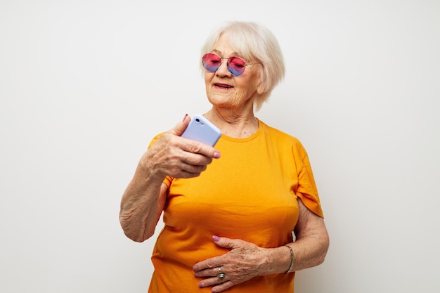 Photo d'une vieille dame à la retraite dans un t-shirt jaune posant la communication par téléphone gros plan émotions