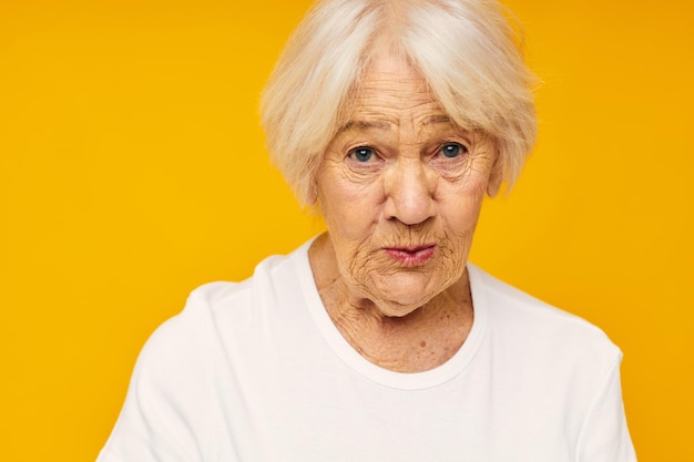 Photo de vieille dame à la retraite posant visage grimace joie fond jaune