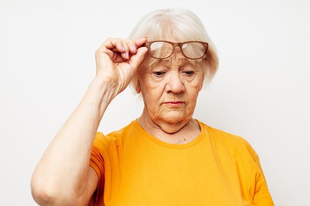 Photo de vieille dame à la retraite en t-shirt décontracté et lunettes fond isolé