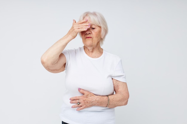 Photo de vieille dame à la retraite tenant sa tête problème de mécontentement fond clair