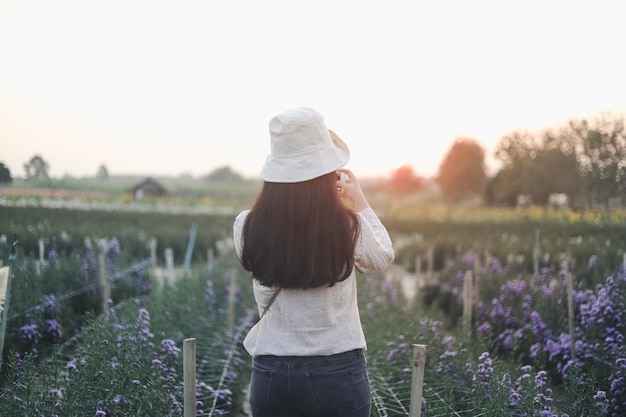 Photo vintage de jeune femme relaxante dans le jardin fleuri.