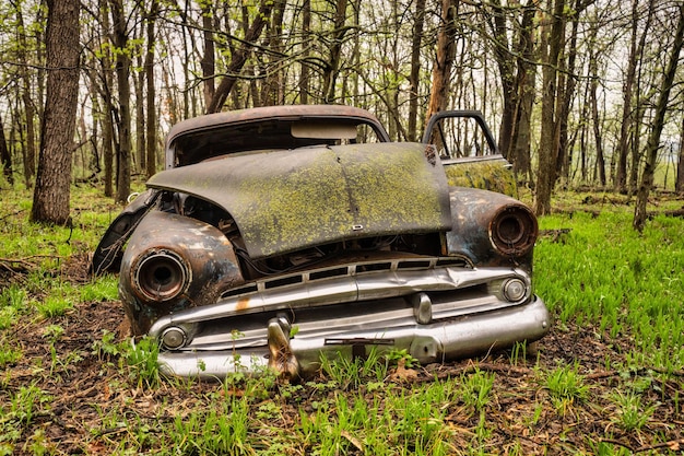 Photo photo d'une voiture abandonnée dans une forêt