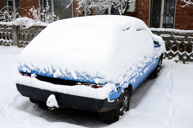 Photo d&#39;une voiture recouverte d&#39;une épaisse couche de neige. Conséquences de fortes chutes de neige