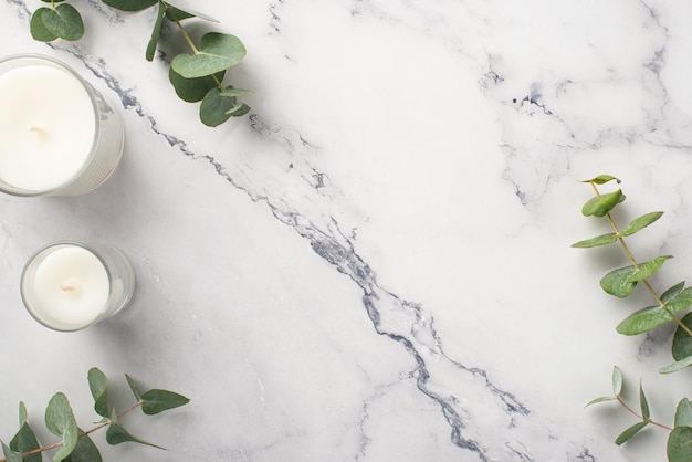 Photo vue de dessus de bougies avec porte-verres et eucalyptus sur fond de marbre blanc avec fond