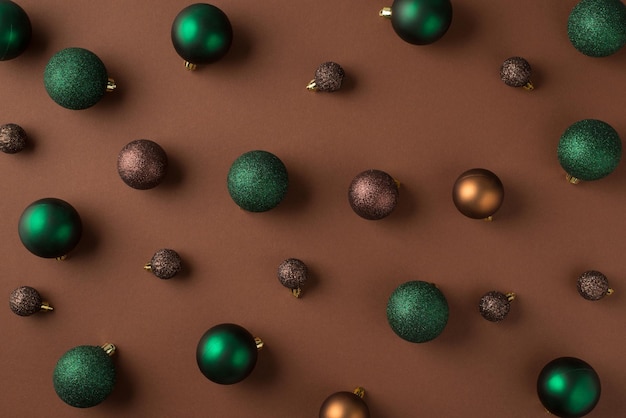 Photo vue de dessus de boules de sapin de noël marron vert et doré sur fond marron isolé