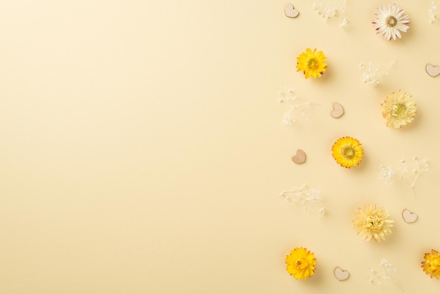 Photo vue de dessus de la composition de la journée de la femme fleurs et coeurs de champ jaune et blanc sur fond beige isolé avec espace vide